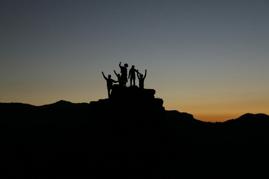 A group of people at the top of a rock.