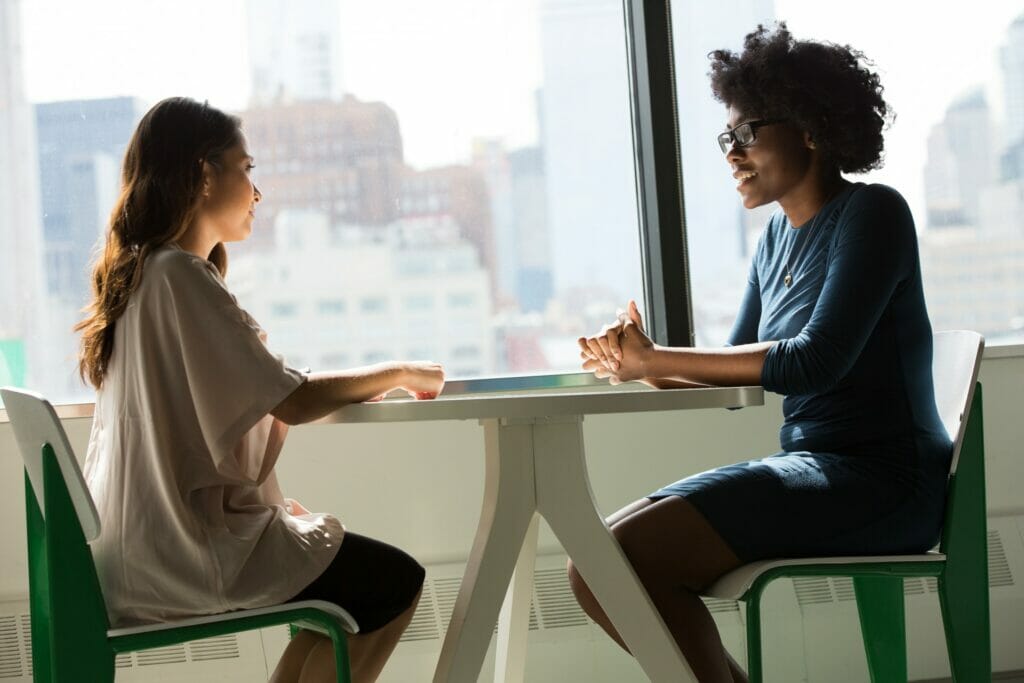 Dos personas sentadas y hablando entre ellas como ejemplo de retroalimentación.